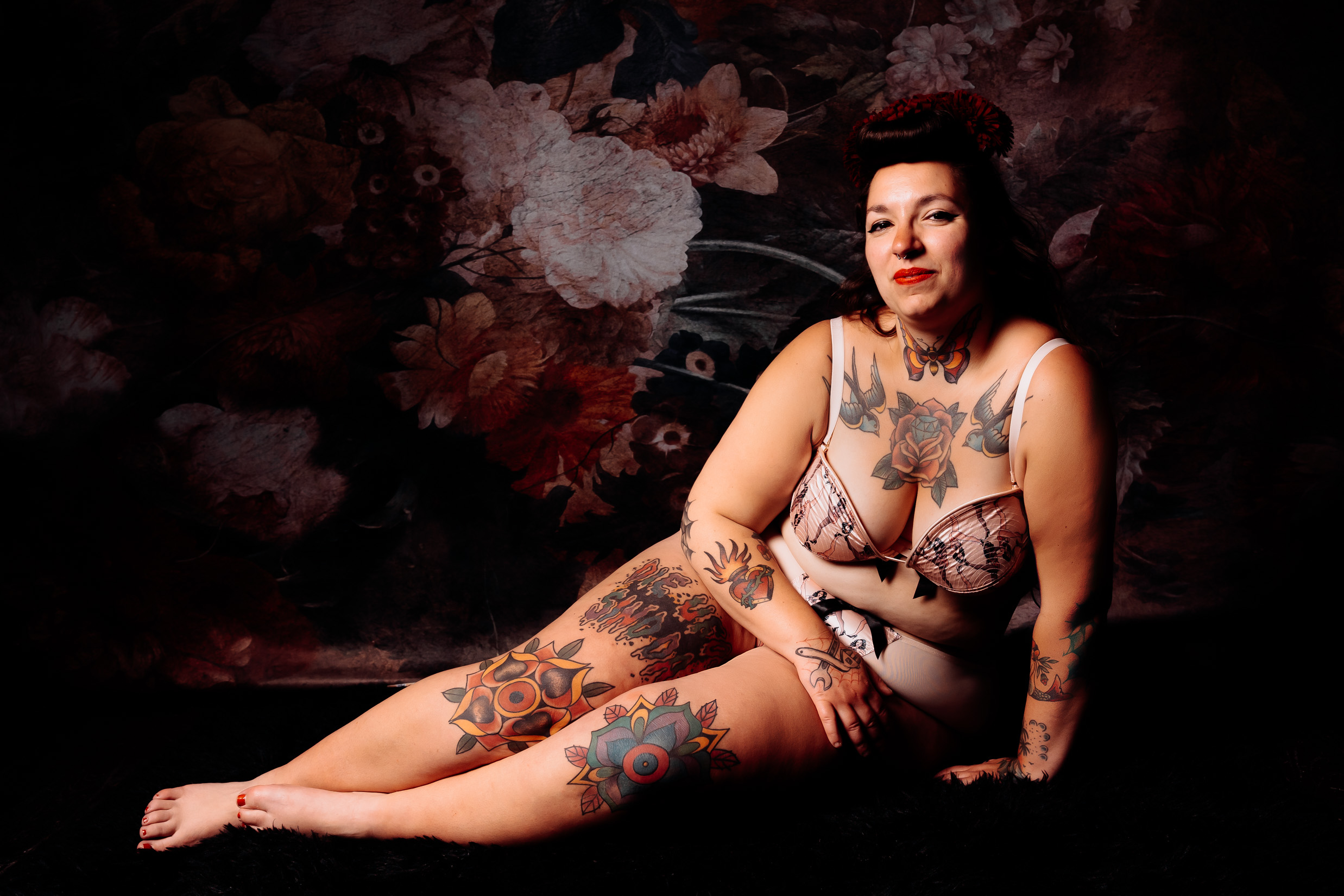 une jeune femme tatouée pose en lingerie lors d'une seance estime de soi
