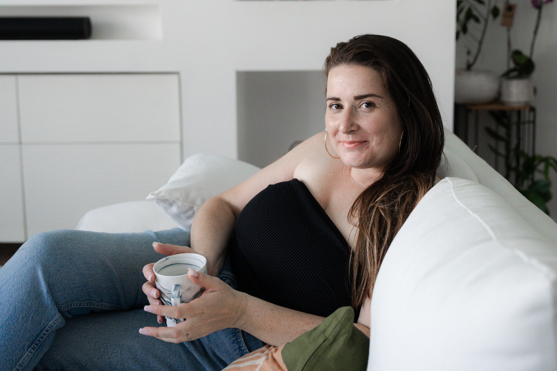 portrait d'une femme qui a le cancer du sein qui pose dans son salon lors d'une séance photo à domicile.