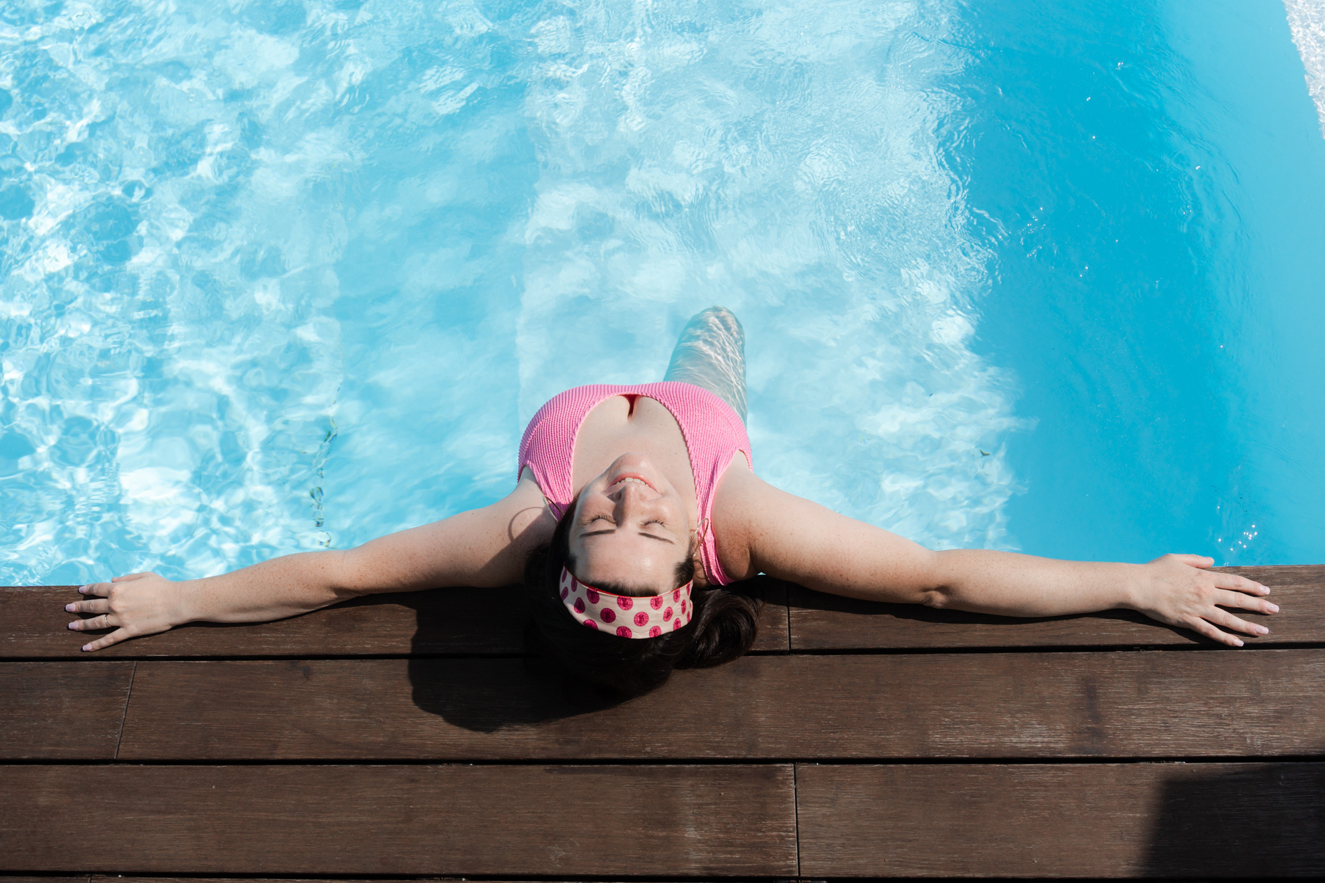 portrait d'une femme qui a le cancer du sein qui pose dans sa piscine lors d'une séance photo à domicile.