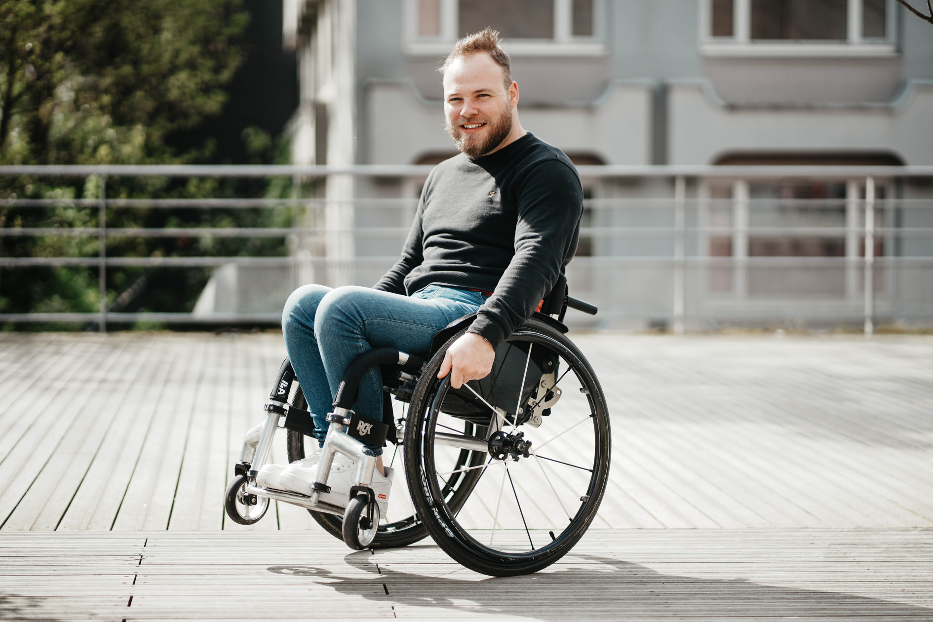 projet photo estime de soi pour des hommes tétraplegique, un jeune homme en fauteuil roulant prend la pose devant l'appareil photo