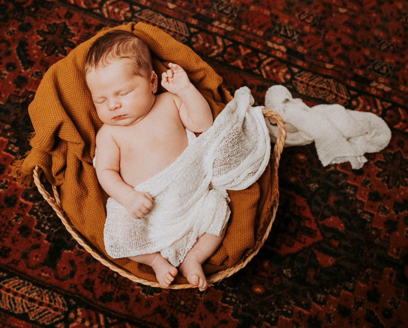 seance-photo-bebe-nouveau-ne-studio-frederique-jouvin-rennes.jpg Bébé endormi emmailloté dans une couverture ocre pendant une séance photo nouveau-né au studio Frédérique Jouvin à Rennes.